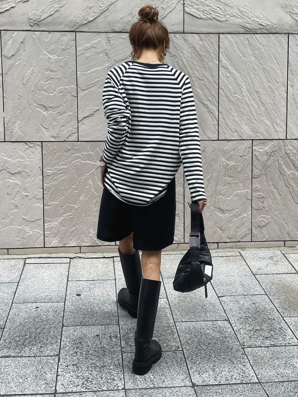ホワイト系のTシャツ/カットソー、ブラック系のパンツ、ブラック系のブーツを着用したレディースの秋コーディネートの2枚目の写真