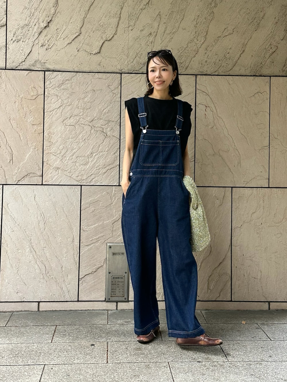 ブルー系のサロペット/オーバーオール、ブラック系のTシャツ/カットソーを着用したレディースの春コーディネートの2枚目の写真