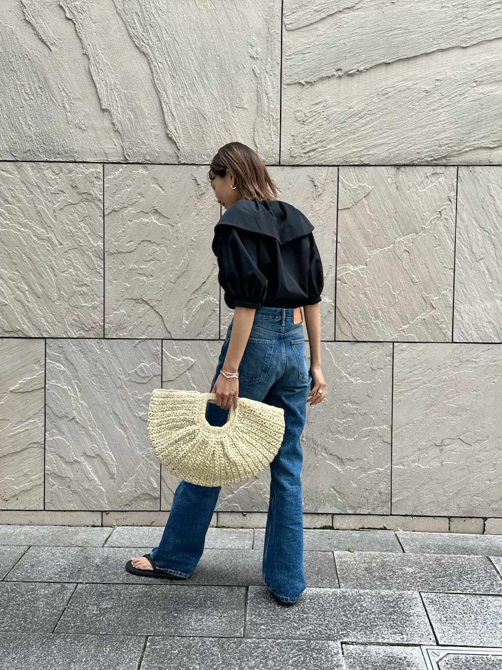 ブラック系のシャツ/ブラウス、ブルー系のデニムパンツ、ブラック系のサンダルを着用したレディースの春コーディネートの2枚目の写真