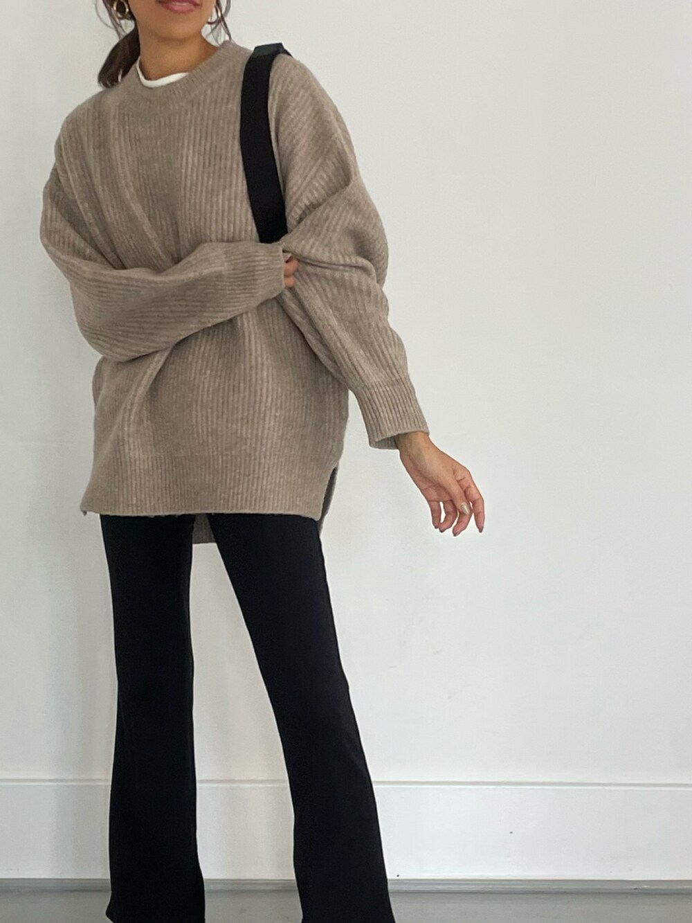 ベージュ系のニット/セーター、ブラック系のボディバッグ/ウエストポーチ、ブラック系のレギンス/スパッツを着用したレディースの秋コーディネートの3枚目の写真