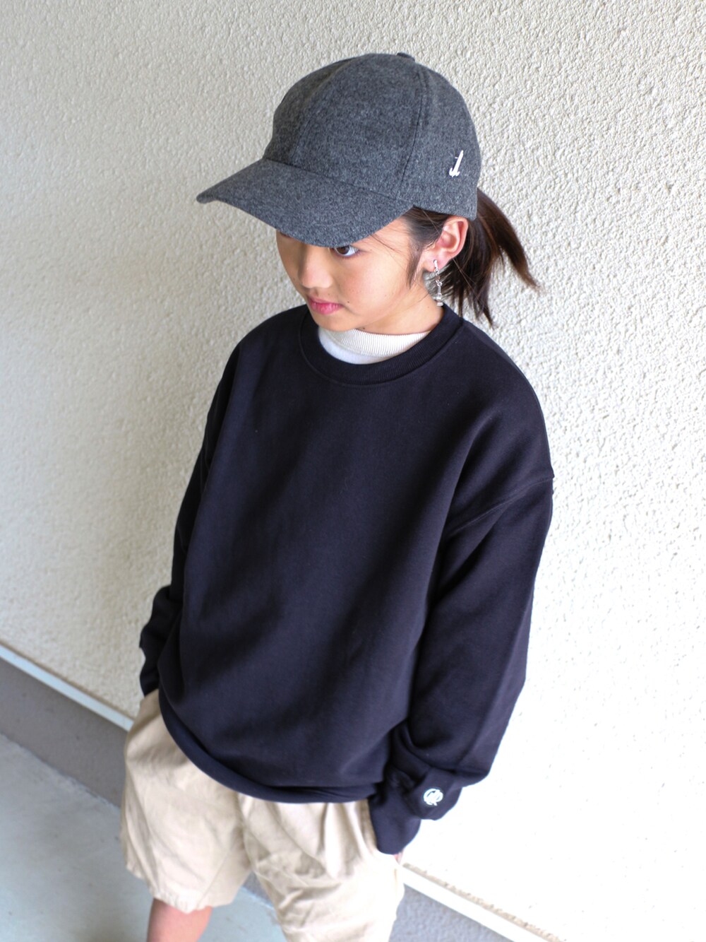 ブラック系のスウェット、ベージュ系のチノパンツ、ブラック系のスニーカーを着用したキッズの秋コーディネートの4枚目の写真