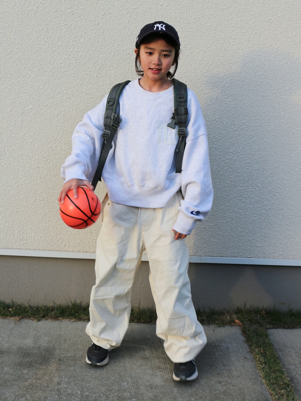 ホワイト系のスウェット、ホワイト系のその他パンツ、グリーン系のバックパック/リュックを着用したキッズの冬コーディネートの2枚目の写真