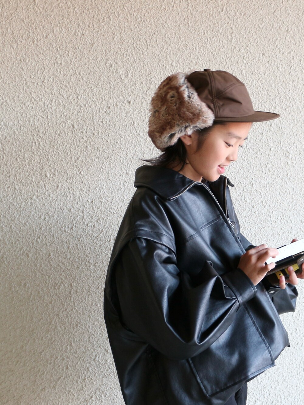 ブラック系のジャケット/アウター、ブラウン系のスニーカー、ブラック系のパンツを着用したキッズの冬コーディネートの2枚目の写真