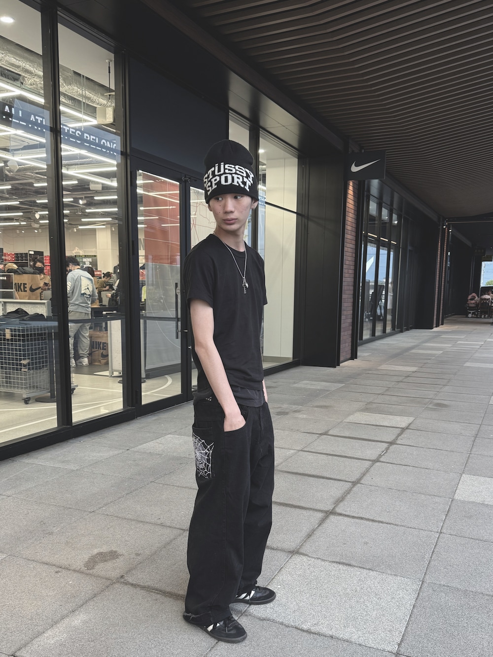 ブラック系のデニムパンツ、ブラック系のTシャツ/カットソー、ブラック系のニットキャップ/ビーニーを着用したメンズの春コーディネートの2枚目の写真