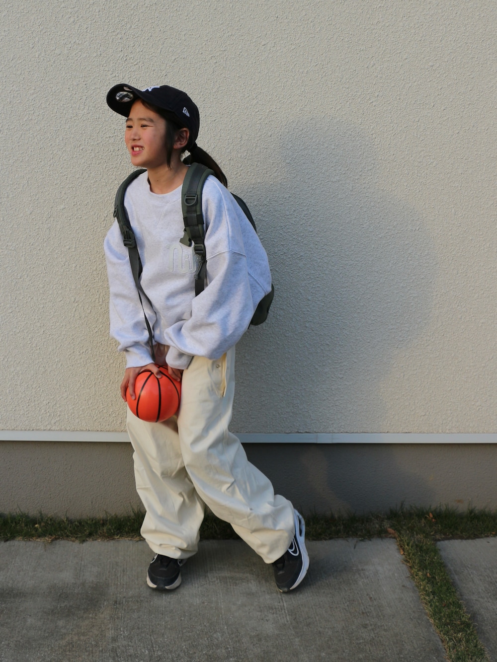 ホワイト系のスウェット、ホワイト系のその他パンツ、グリーン系のバックパック/リュックを着用したキッズの冬コーディネートの3枚目の写真