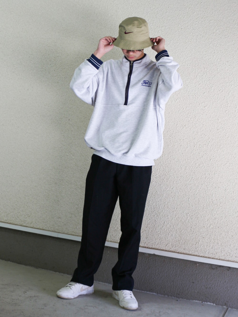 グレー系のスウェット、ブルー系のスラックス、ホワイト系のスニーカーを着用したメンズの春コーディネートの2枚目の写真