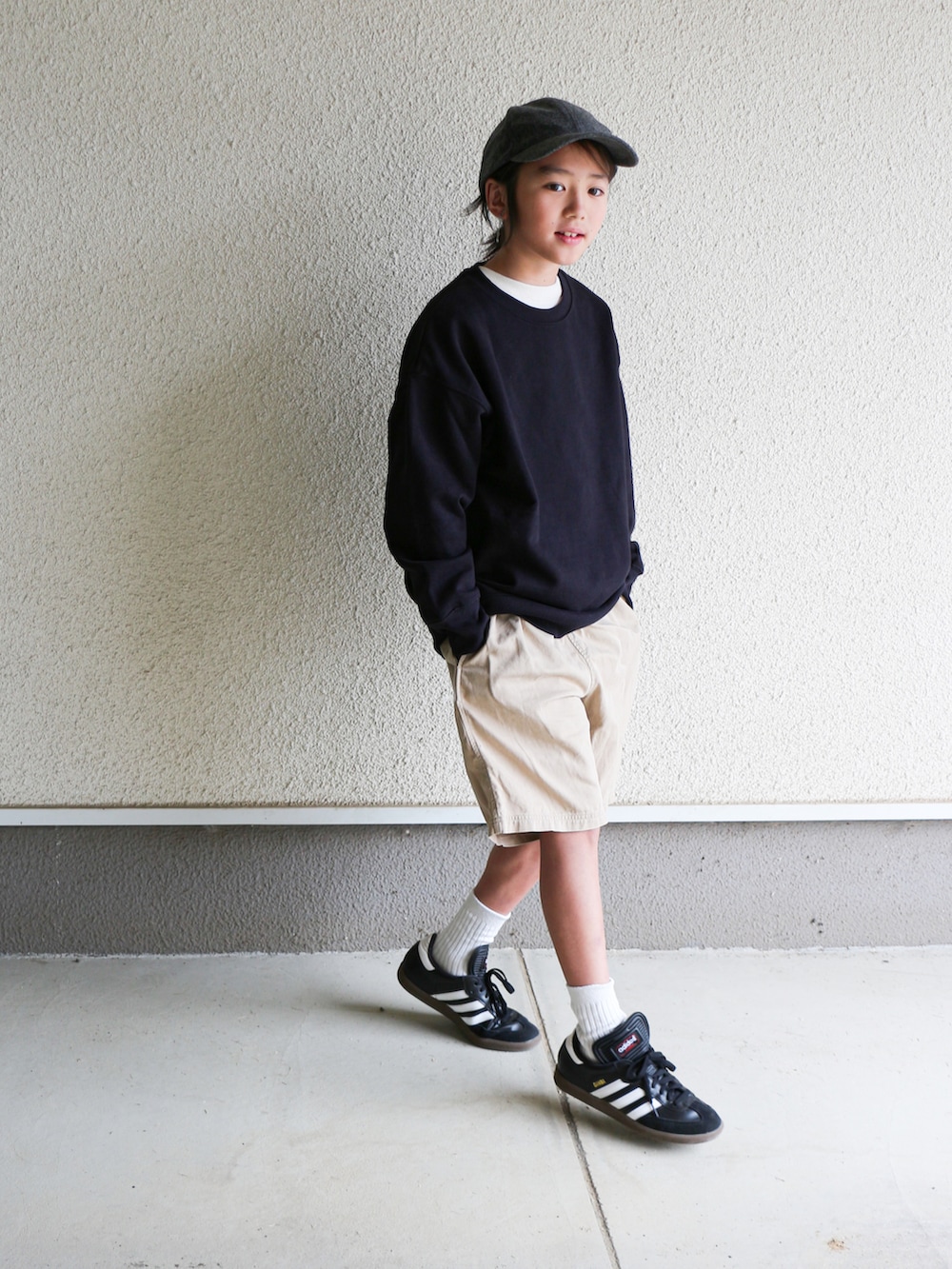 ブラック系のスウェット、ベージュ系のチノパンツ、ブラック系のスニーカーを着用したキッズの秋コーディネートの3枚目の写真
