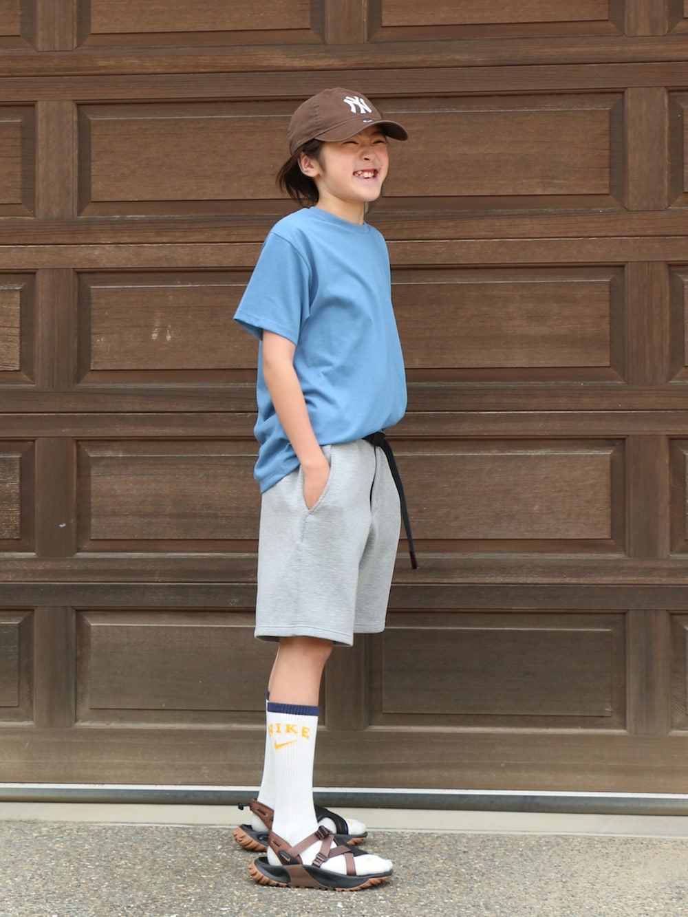 ブルー系のTシャツ/カットソー、グレー系のパンツ、ブラウン系のサンダルを着用したキッズの春コーディネートの2枚目の写真