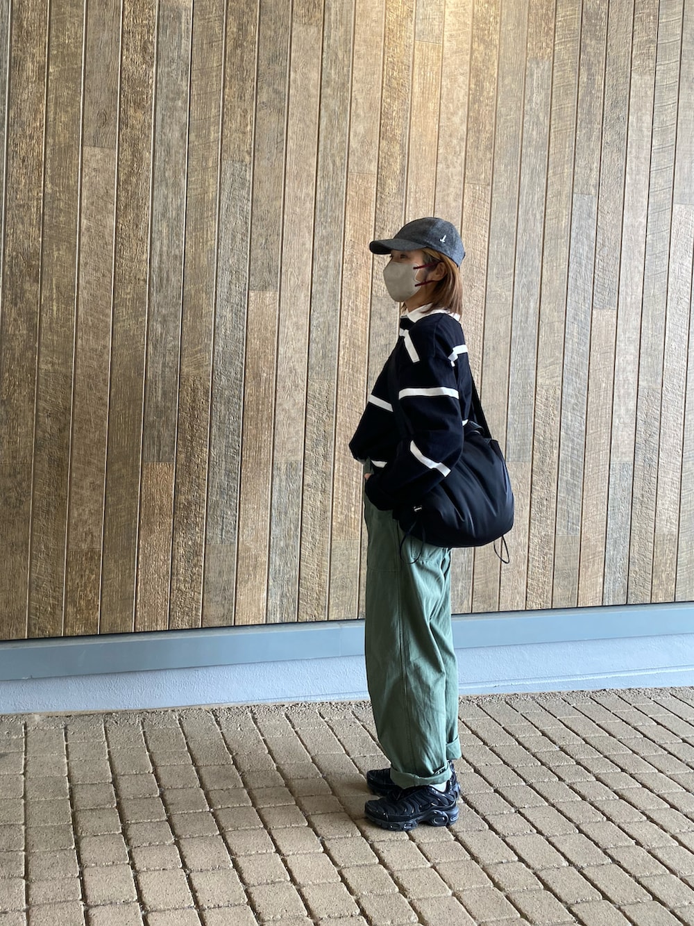 ブラック系のTシャツ/カットソー、ブラック系のショルダーバッグ、グリーン系のその他パンツを着用したレディースの春コーディネートの2枚目の写真