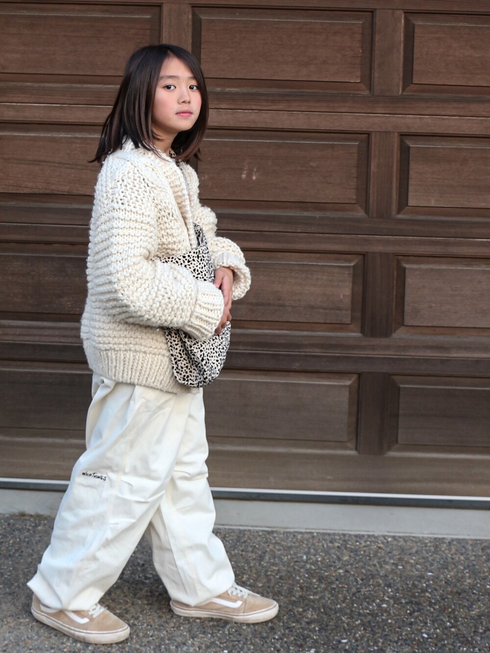 ホワイト系のその他パンツ、ホワイト系のカーディガン/ボレロ、ベージュ系のスニーカーを着用したキッズの冬コーディネートの3枚目の写真