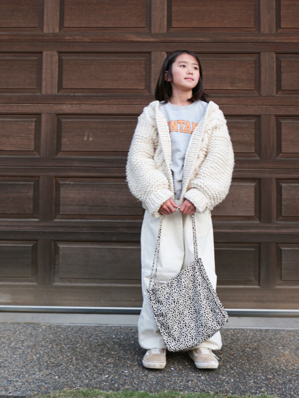 ホワイト系のその他パンツ、ホワイト系のカーディガン/ボレロ、ベージュ系のスニーカーを着用したキッズの冬コーディネートの2枚目の写真
