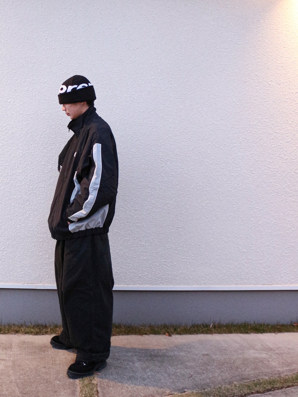 ブラック系のナイロンジャケット、ブラック系のカーゴパンツ、ブラック系のスニーカーを着用したメンズの冬コーディネートの2枚目の写真