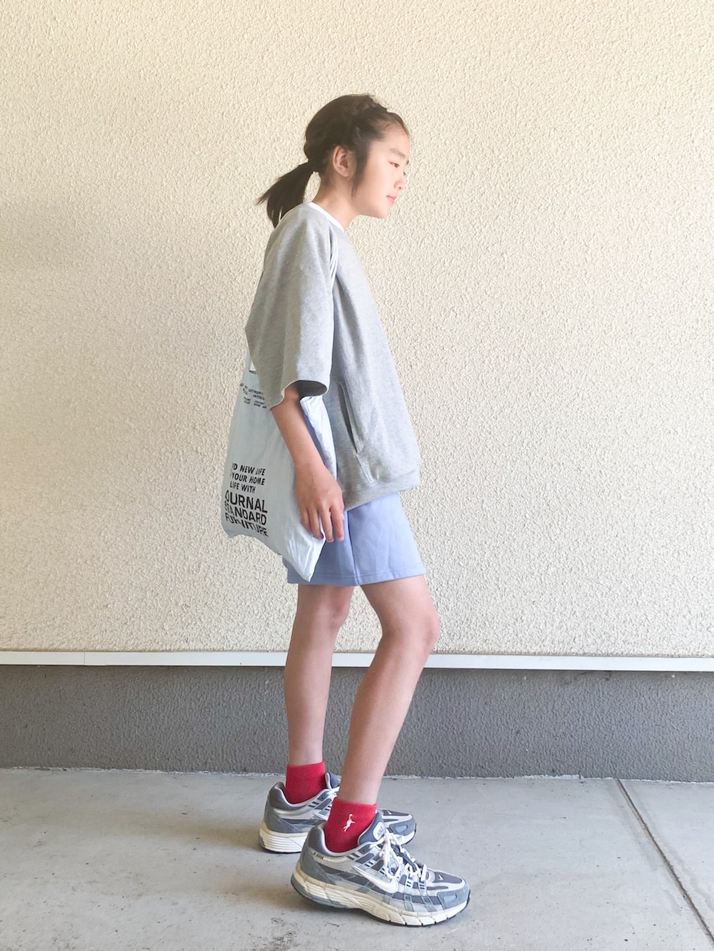 グレー系のスニーカー、ブルー系のトートバッグ、グレー系のTシャツ/カットソーを着用したキッズの春コーディネートの2枚目の写真