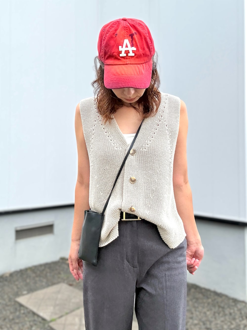 ブラック系のサンダル、グレー系のスラックス、ベージュ系のベストを着用したレディースの夏コーディネートの4枚目の写真