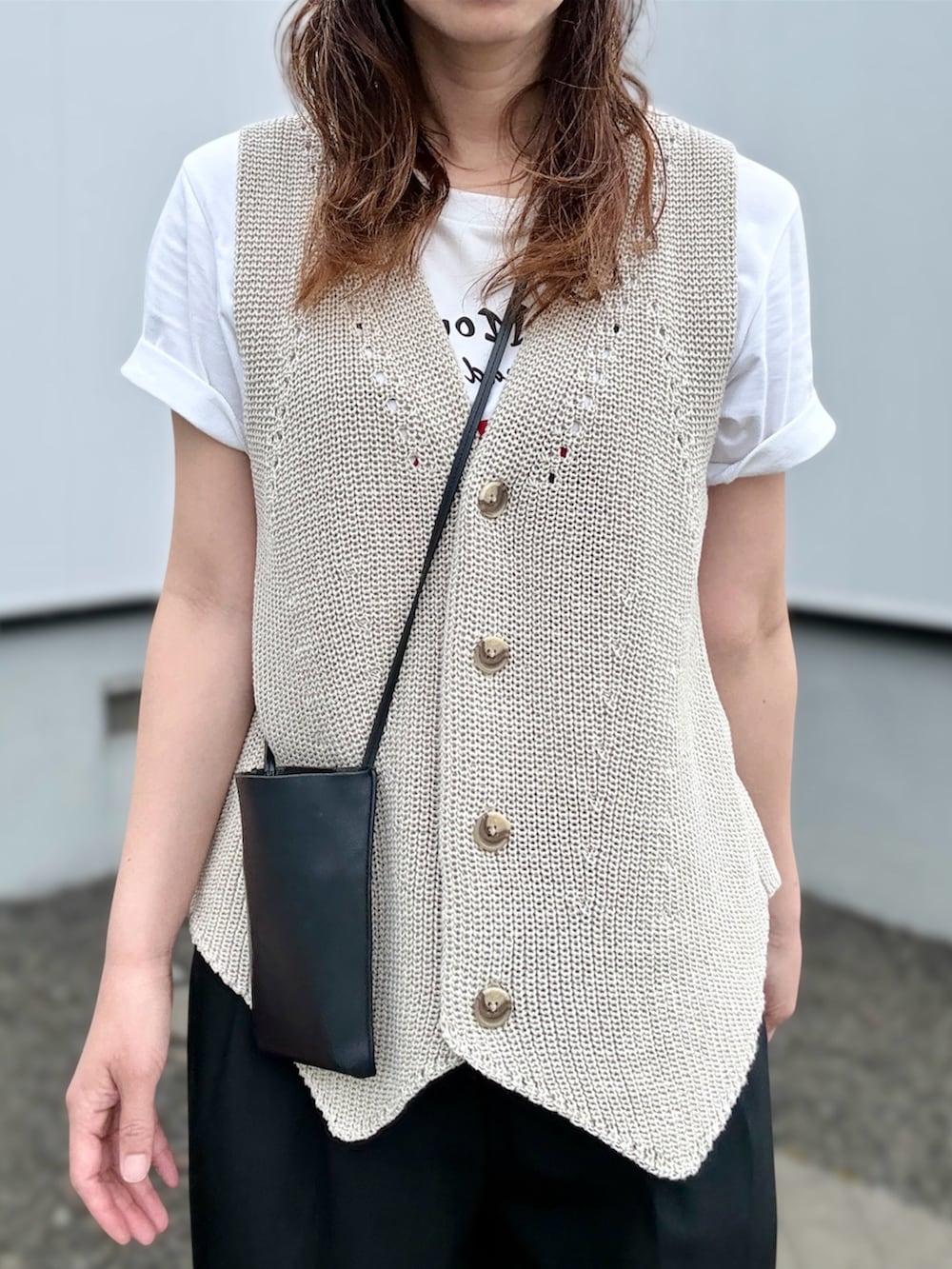 ブラック系のスニーカー、ベージュ系のベスト、ブラック系のその他パンツを着用したレディースの夏コーディネートの2枚目の写真