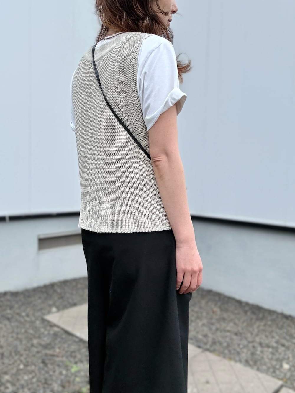 ブラック系のスニーカー、ベージュ系のベスト、ブラック系のその他パンツを着用したレディースの夏コーディネートの5枚目の写真