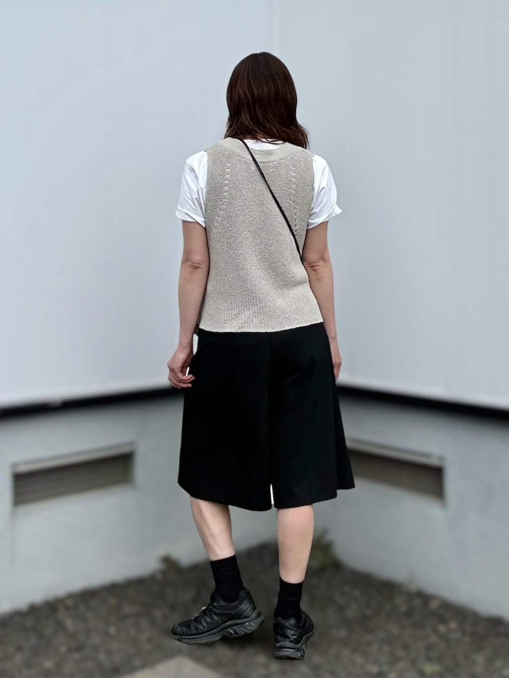 ブラック系のスニーカー、ベージュ系のベスト、ブラック系のその他パンツを着用したレディースの夏コーディネートの4枚目の写真
