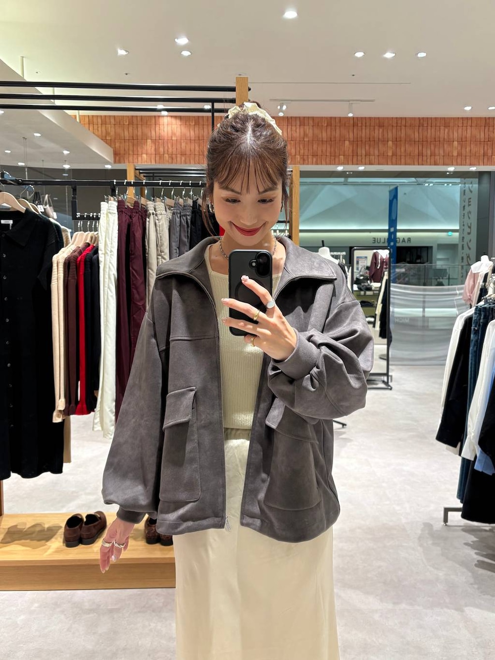 ホワイト系のニット/セーター、ブラック系のショルダーバッグ、グレー系のブルゾンを着用したレディースの秋コーディネートの4枚目の写真