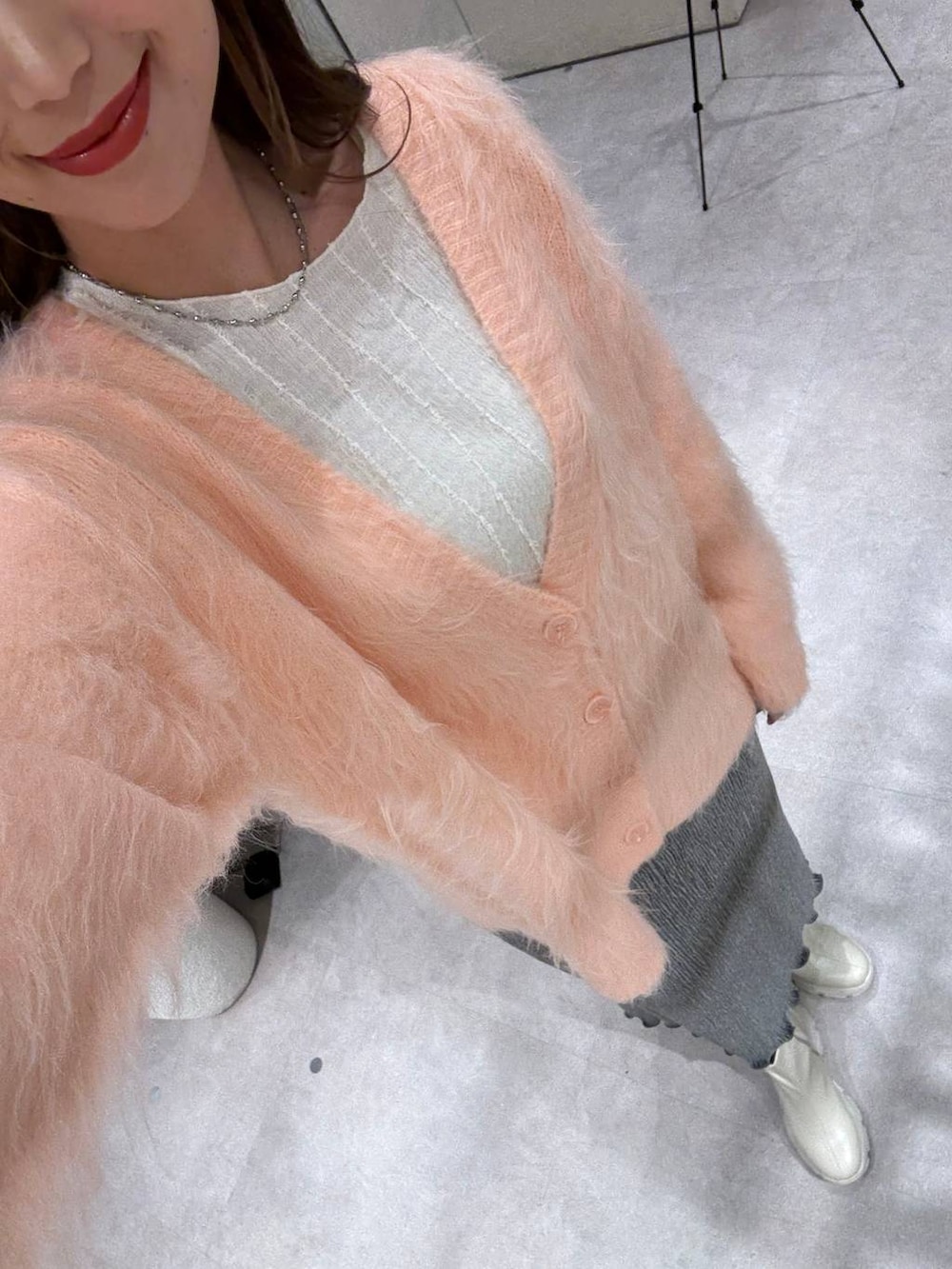 ベージュ系のTシャツ/カットソー、ホワイト系のブーツ、グレー系のスカートを着用したレディースの秋コーディネートの3枚目の写真