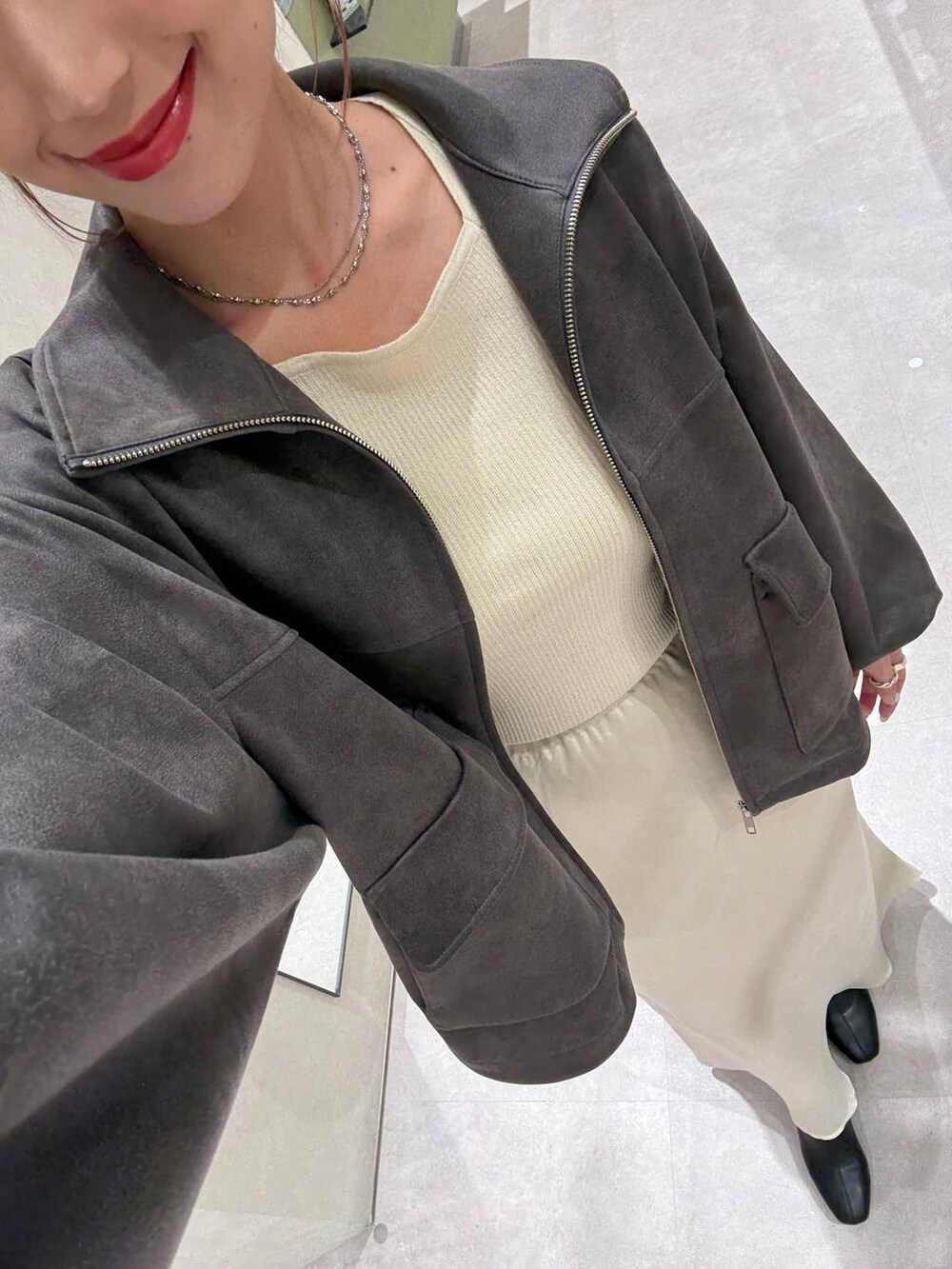 ホワイト系のニット/セーター、ブラック系のショルダーバッグ、グレー系のブルゾンを着用したレディースの秋コーディネートの3枚目の写真