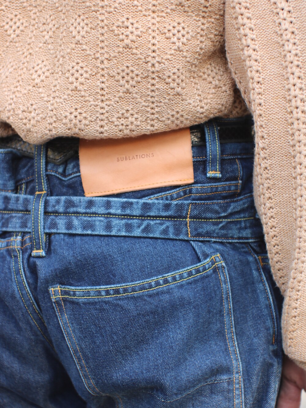 ブルー系のデニムパンツ、ブラック系のブーツ、ブラック系のハンドバッグを着用したメンズの秋コーディネートの4枚目の写真