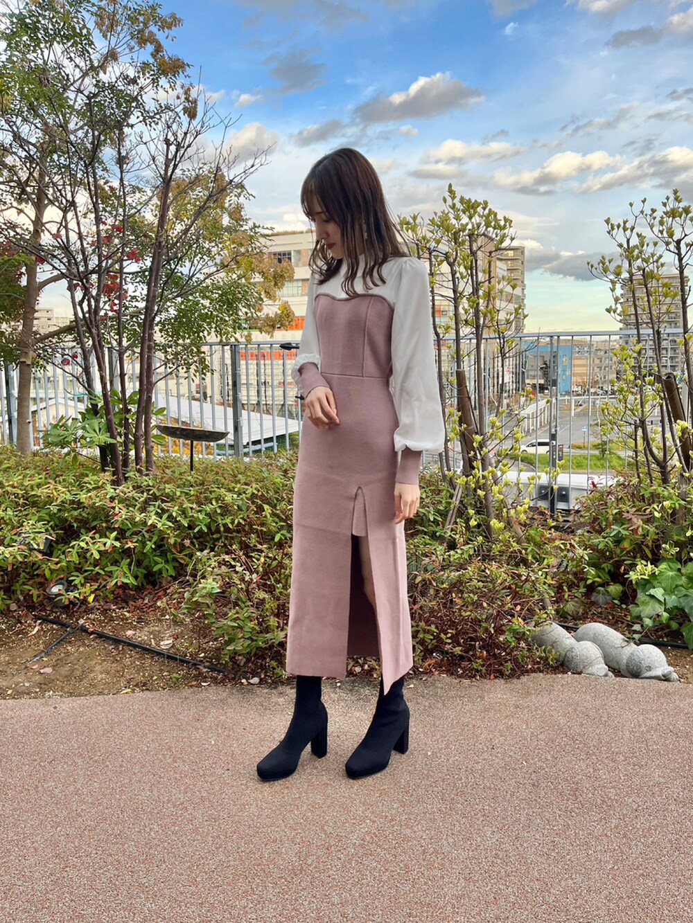 ピンク系のワンピースを着用したレディースの秋コーディネートの2枚目の写真