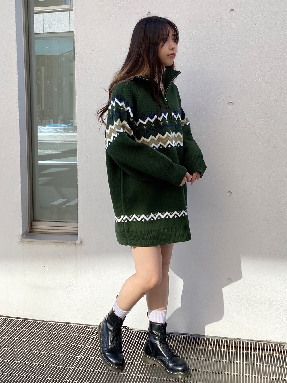 グリーン系のワンピース、ベージュ系のニット/セーターを着用したレディースの冬コーディネートの2枚目の写真
