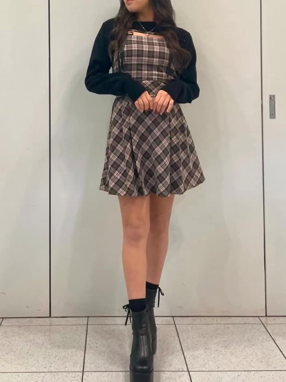 ベージュ系のワンピースを着用したレディースの冬コーディネートの2枚目の写真