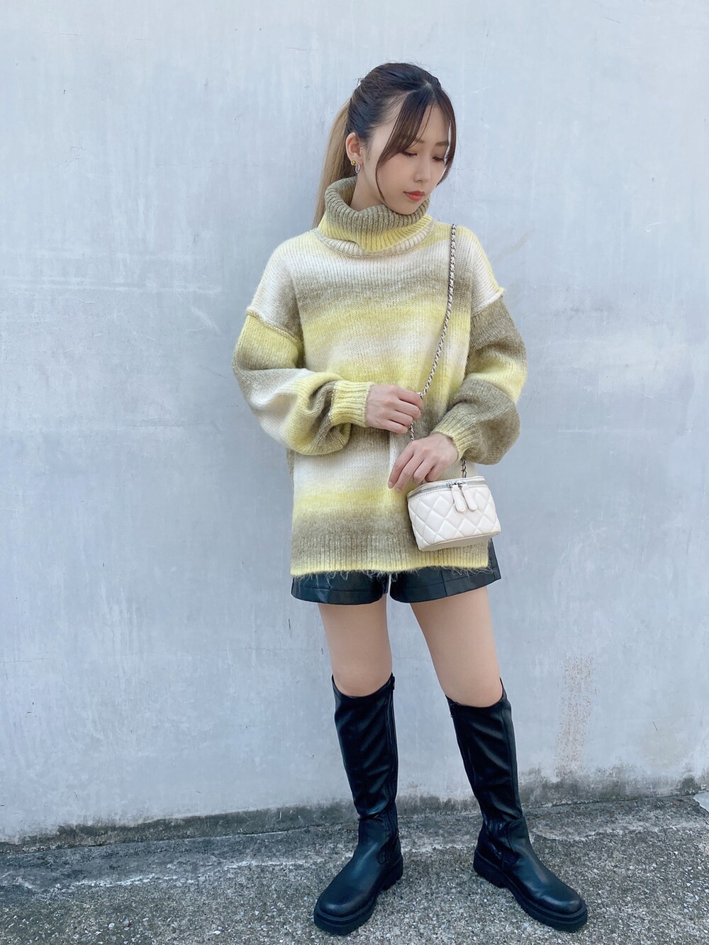 イエロー系のニット/セーターを着用したレディースの秋コーディネートの2枚目の写真