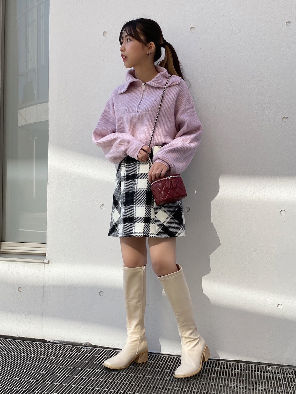 ピンク系のニット/セーター、ホワイト系のスカートを着用したレディースの冬コーディネートの2枚目の写真