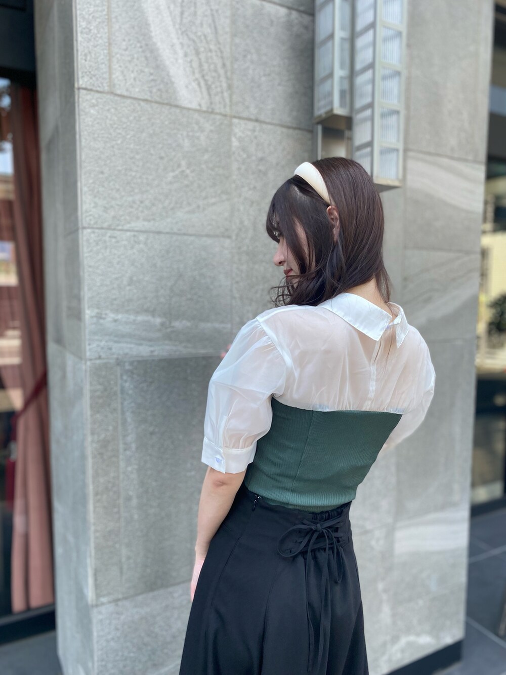 グリーン系のTシャツ/カットソー、ブラック系のスカートを着用したレディースの夏コーディネートの4枚目の写真