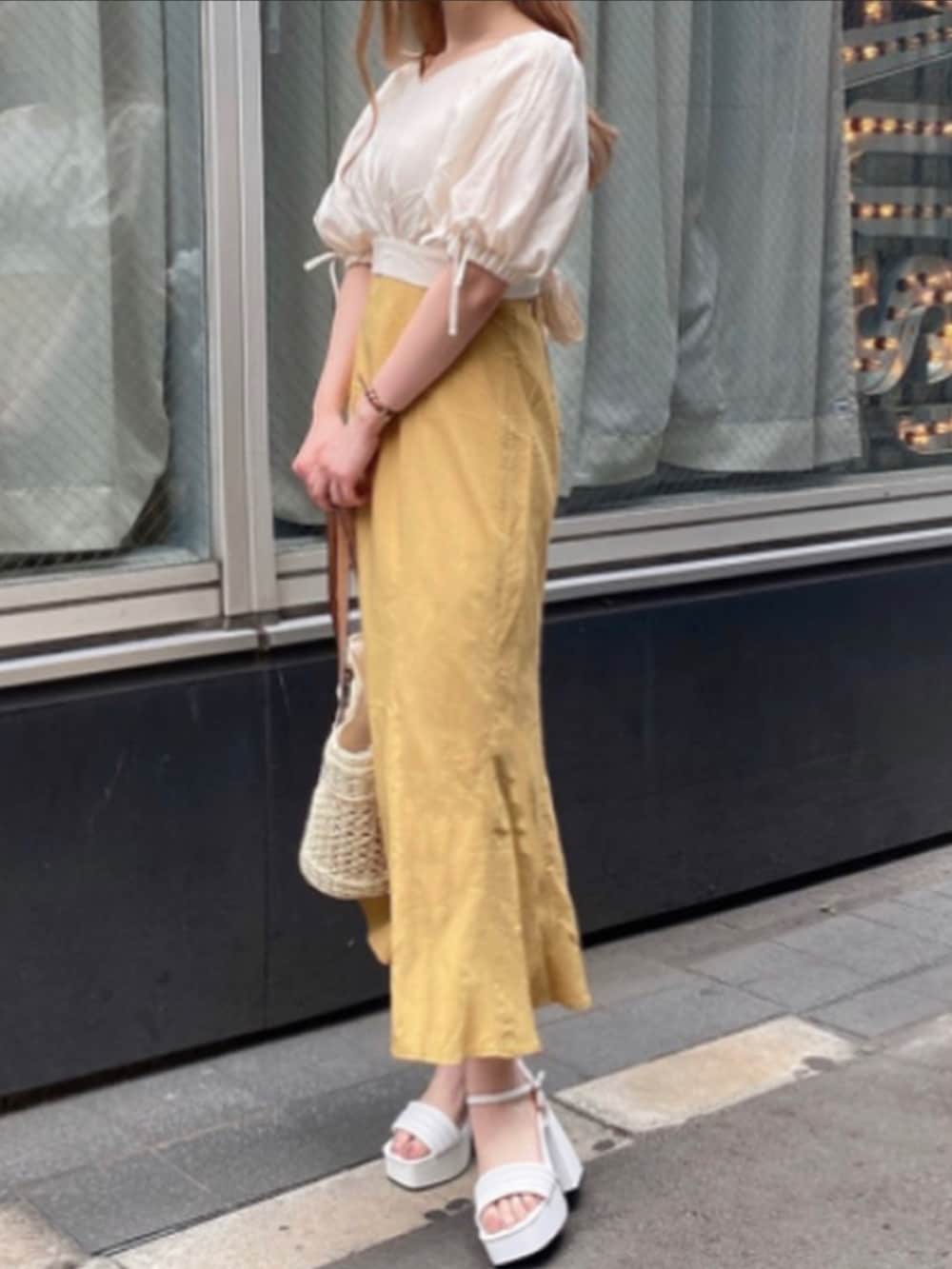 イエロー系のワンピースを着用したレディースの春コーディネートの2枚目の写真