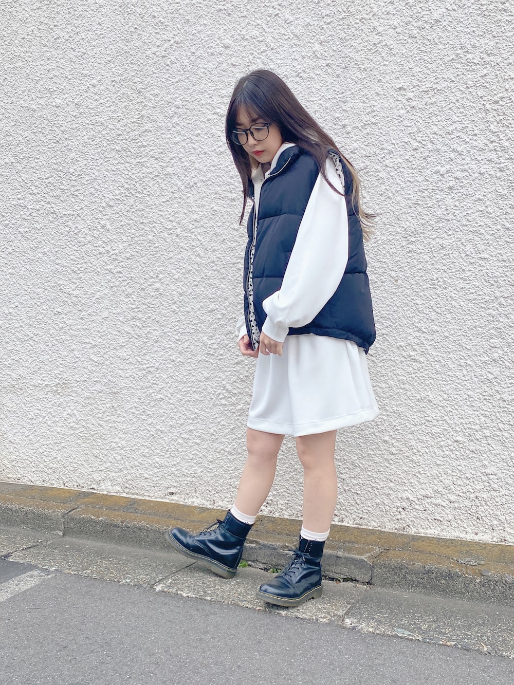 ホワイト系のワンピース、ブラック系のダウンベストを着用したレディースの秋コーディネートの2枚目の写真