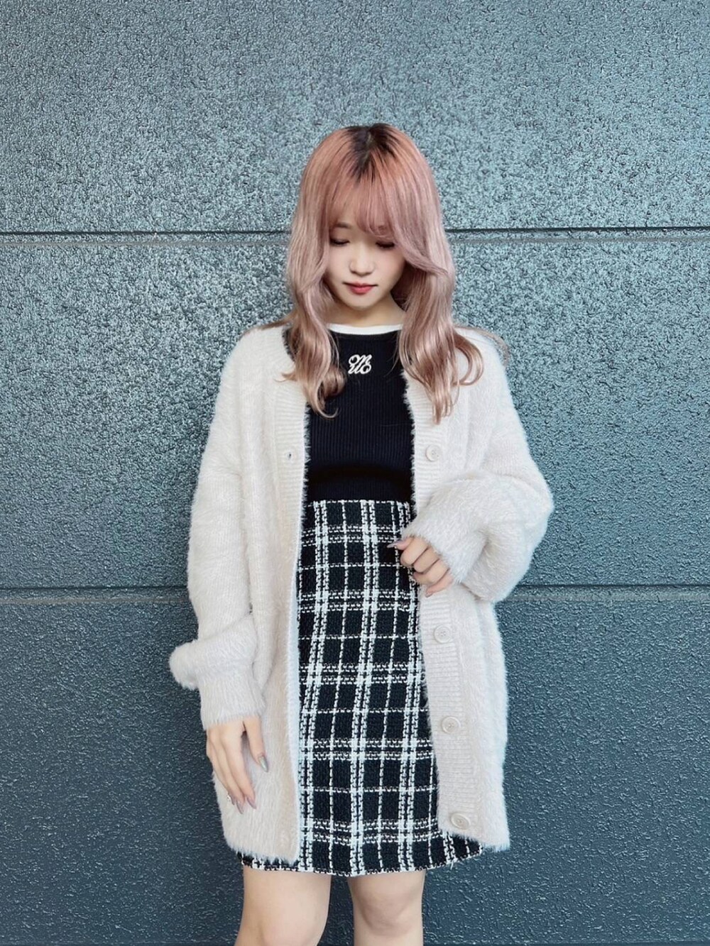 ブラック系のニット/セーター、ベージュ系のカーディガン/ボレロ、ブラック系のスカートを着用したレディースの秋コーディネートの2枚目の写真