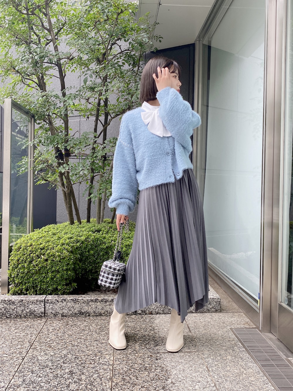 ホワイト系のシャツ/ブラウス、グレー系のスカート、ブルー系のカーディガン/ボレロを着用したレディースの秋コーディネートの2枚目の写真