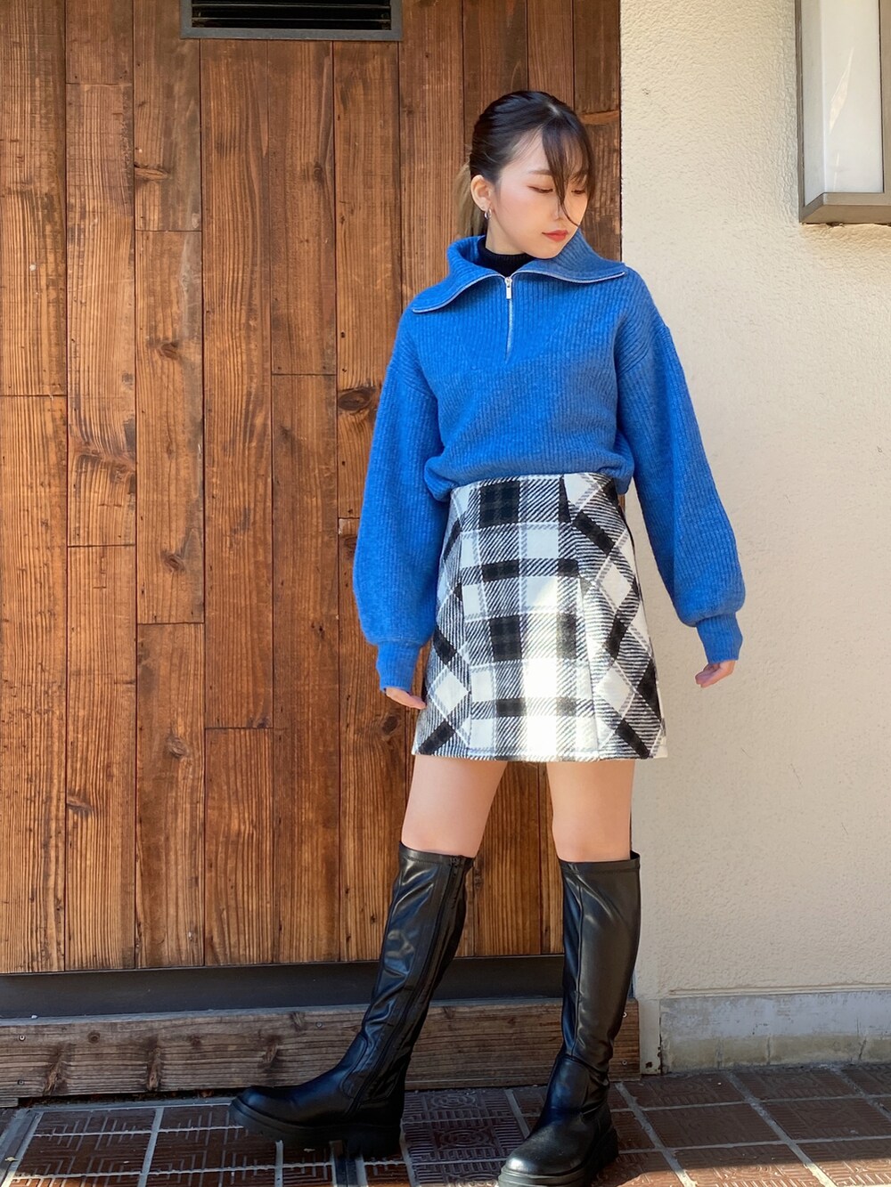 ブルー系のニット/セーター、ブラック系のニット/セーター、ホワイト系のスカートを着用したレディースの冬コーディネートの3枚目の写真