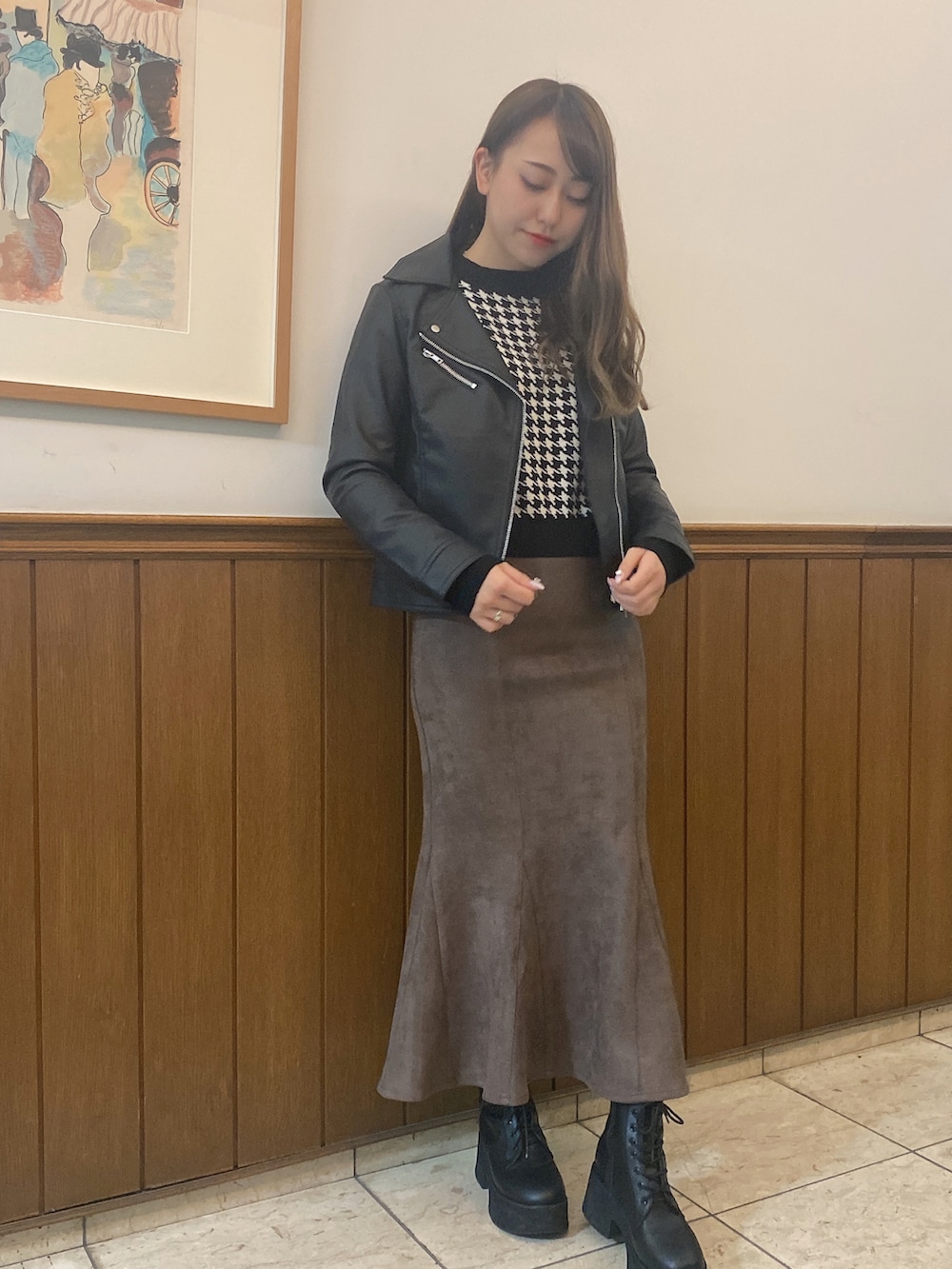 グレー系のスカート、ブラック系のライダースジャケットを着用したレディースの秋コーディネートの2枚目の写真