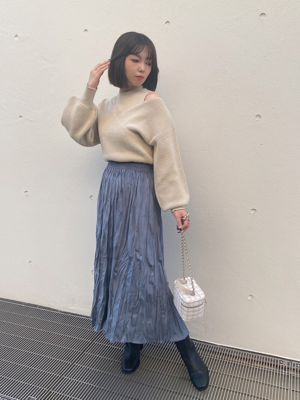 ベージュ系のニット/セーター、ブルー系のスカートを着用したレディースの冬コーディネートの2枚目の写真