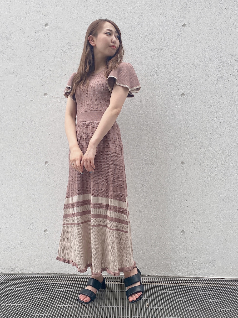 ピンク系のワンピースを着用したレディースの秋コーディネートの2枚目の写真