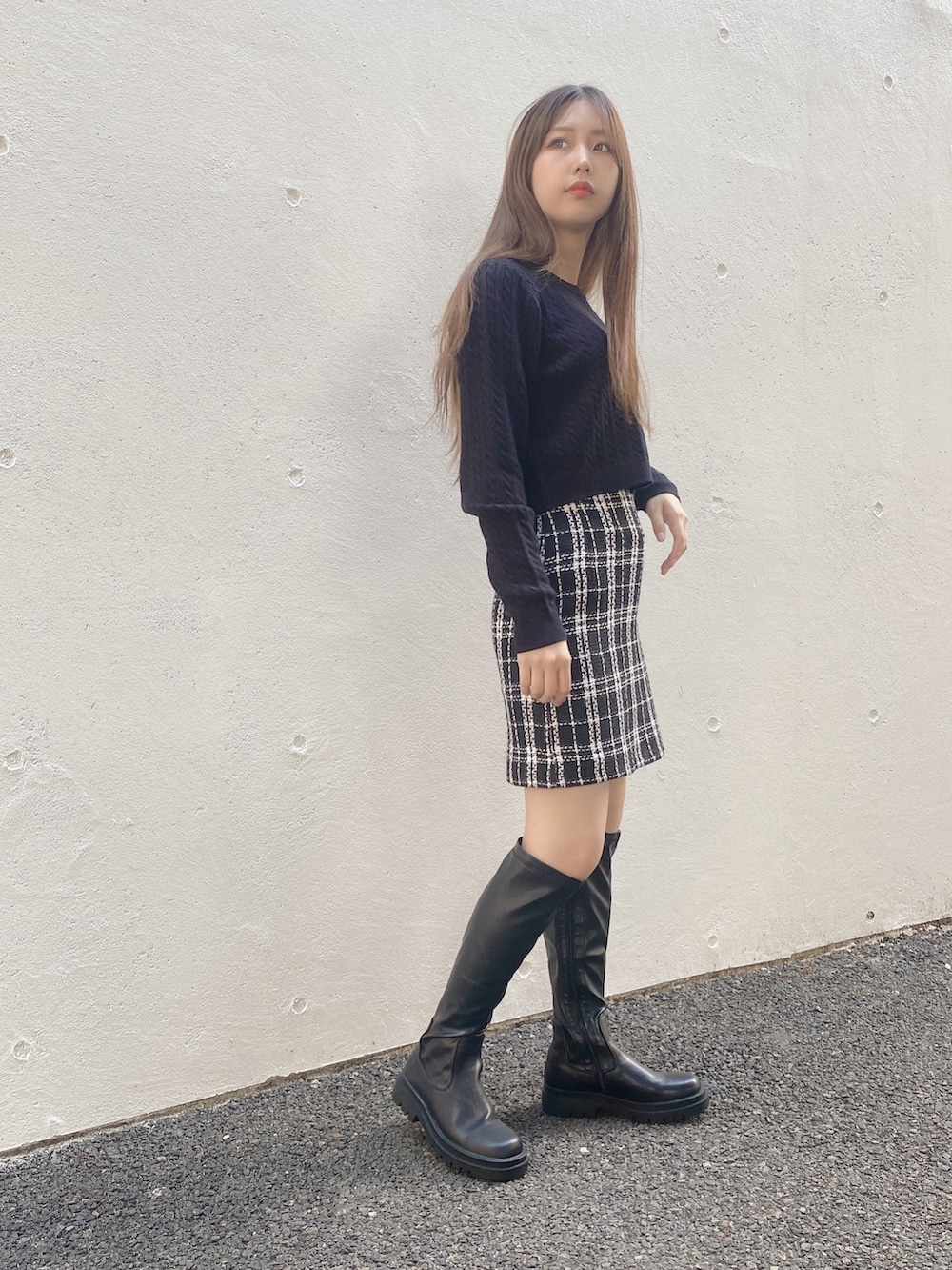 ブラック系のニット/セーター、ブラック系のスカートを着用したレディースの秋コーディネートの2枚目の写真