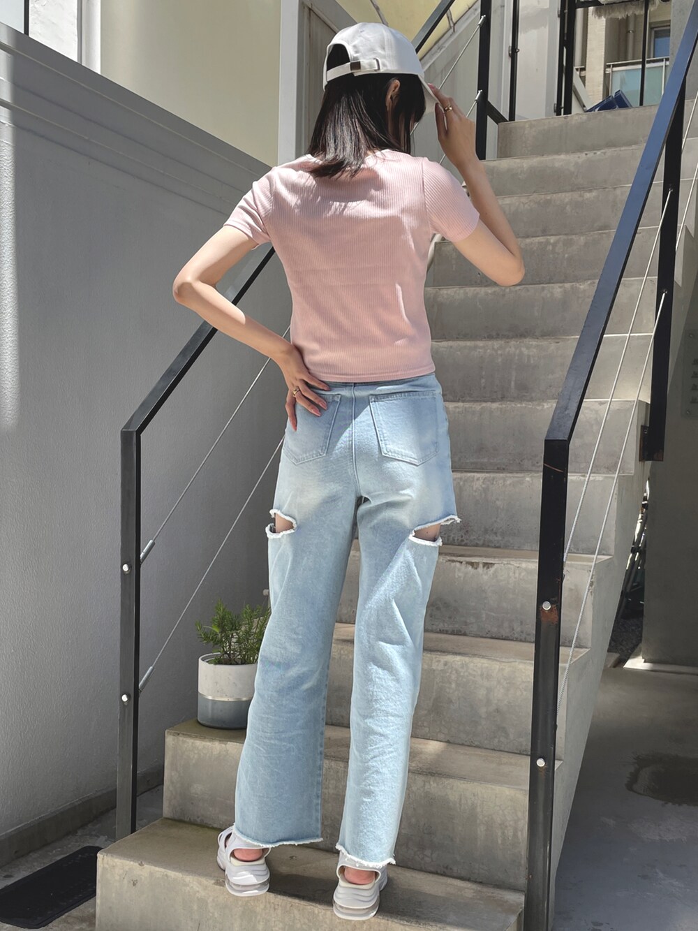 ピンク系のTシャツ/カットソー、ブルー系のデニムパンツを着用したレディースの春コーディネートの2枚目の写真