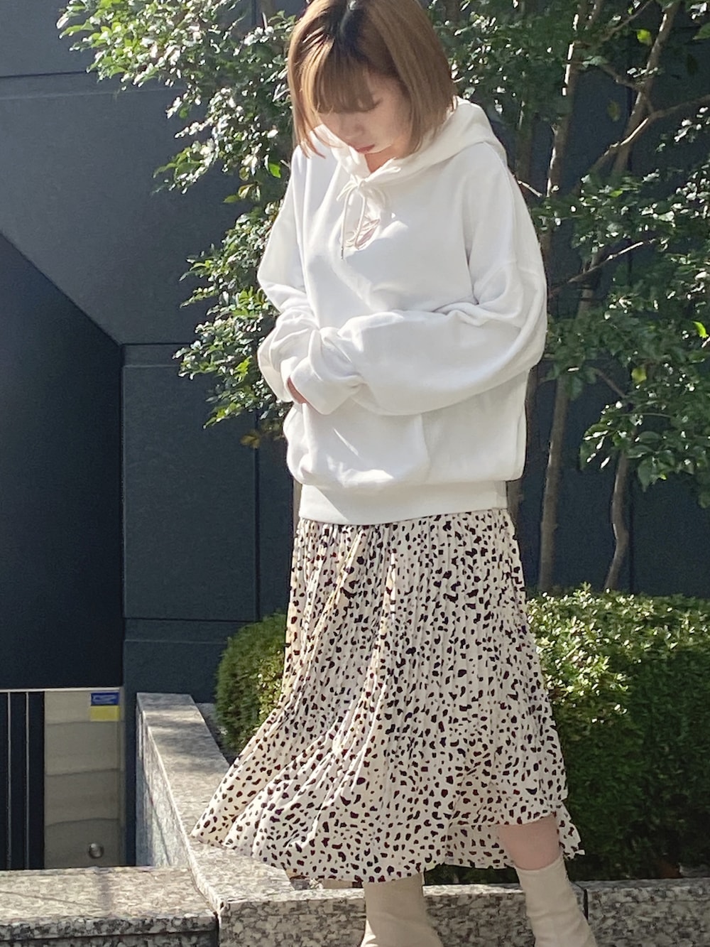 ホワイト系のパーカー、ホワイト系のスカートを着用したレディースの冬コーディネートの2枚目の写真
