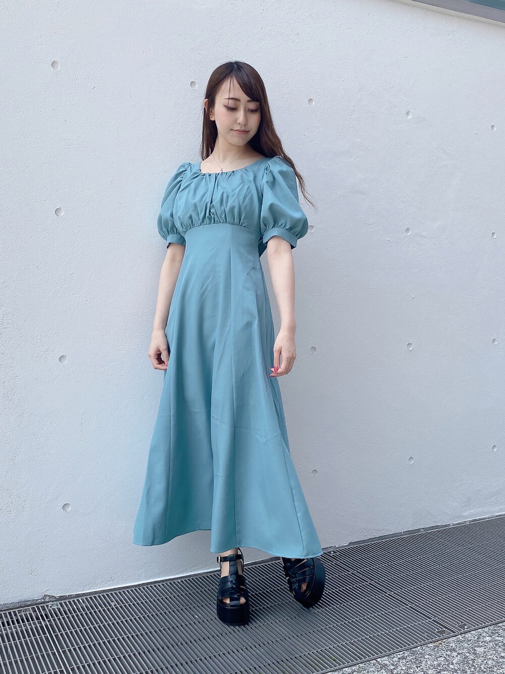 グリーン系のワンピース、ブラック系のサンダルを着用したレディースの夏コーディネートの2枚目の写真