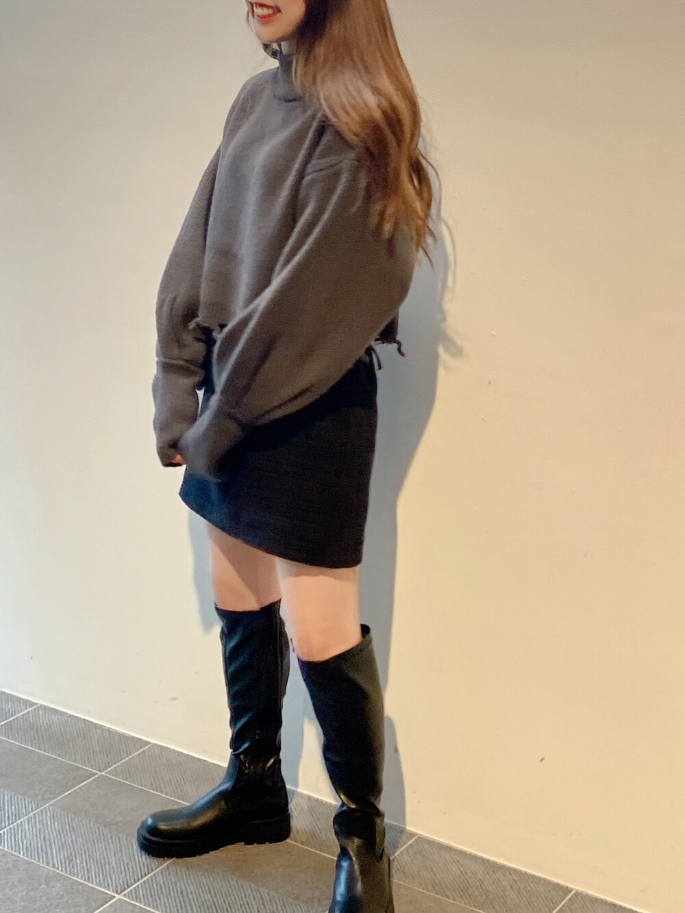 グレー系のニット/セーター、ブラック系のスカートを着用したレディースの冬コーディネートの2枚目の写真