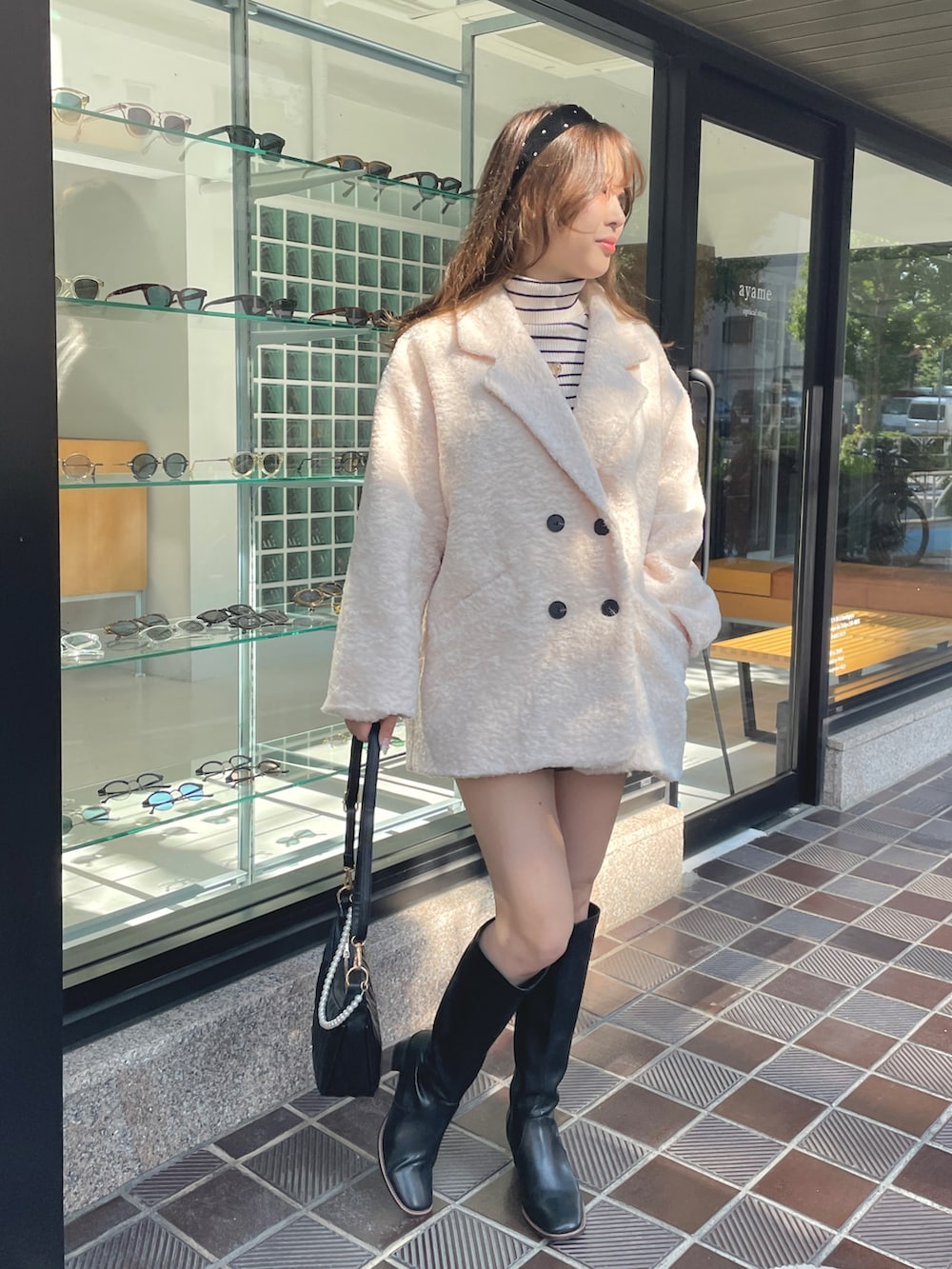 ブラック系のその他パンツ、ホワイト系のその他アウター、ホワイト系のニット/セーターを着用したレディースの冬コーディネートの2枚目の写真