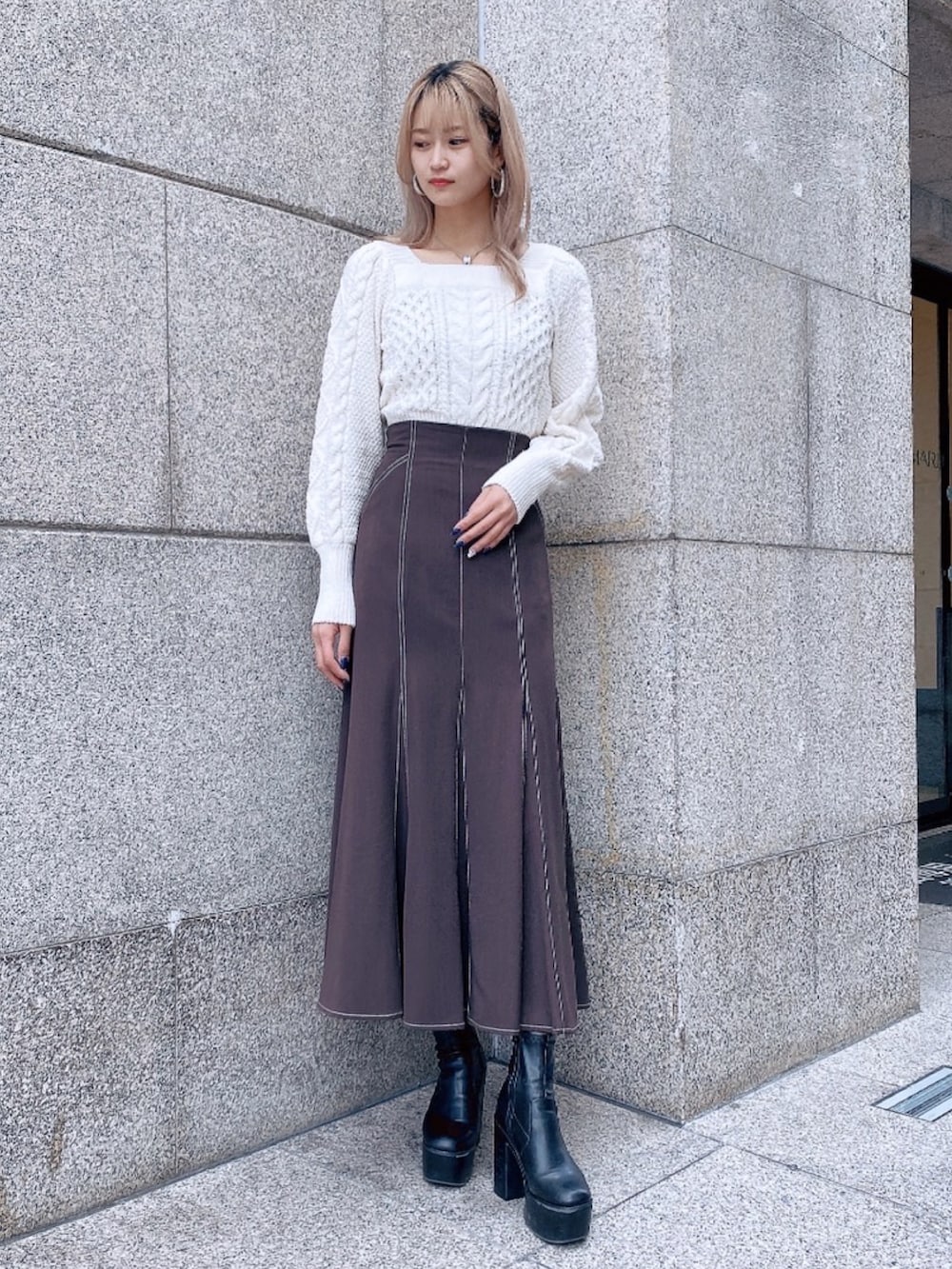 ホワイト系のニット/セーター、ブラウン系のスカートを着用したレディースの秋コーディネートの2枚目の写真