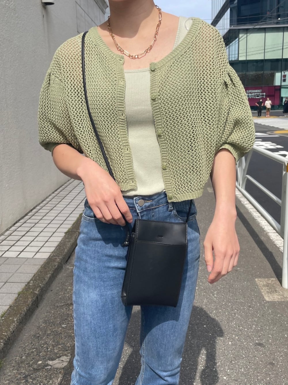 ブルー系のデニムパンツ、グリーン系のキャミソール、グリーン系のカーディガン/ボレロを着用したレディースの夏コーディネートの3枚目の写真