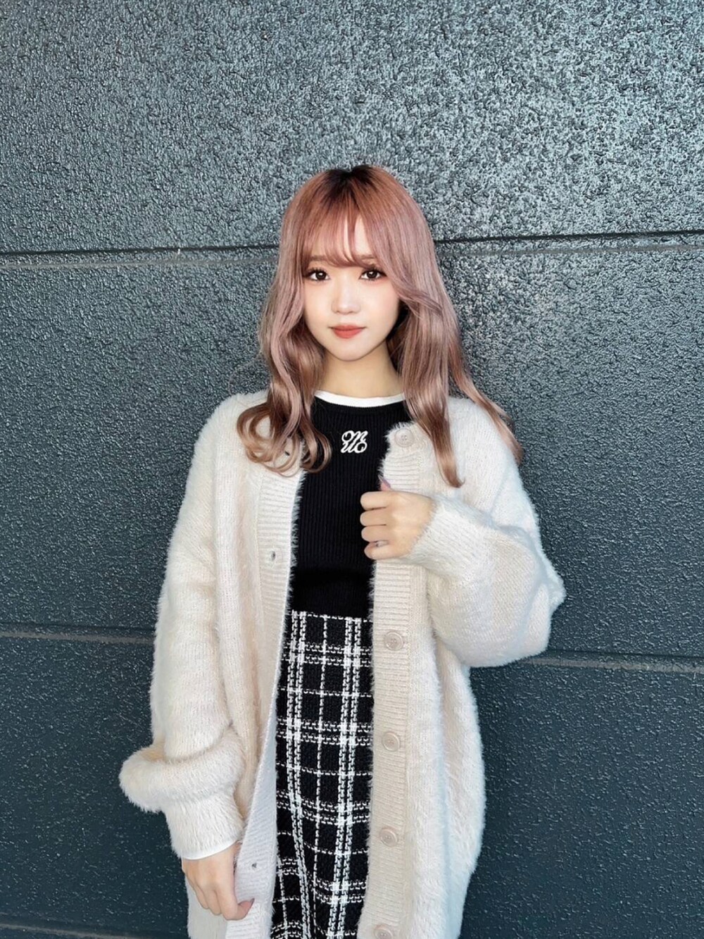 ブラック系のニット/セーター、ベージュ系のカーディガン/ボレロ、ブラック系のスカートを着用したレディースの秋コーディネートの3枚目の写真