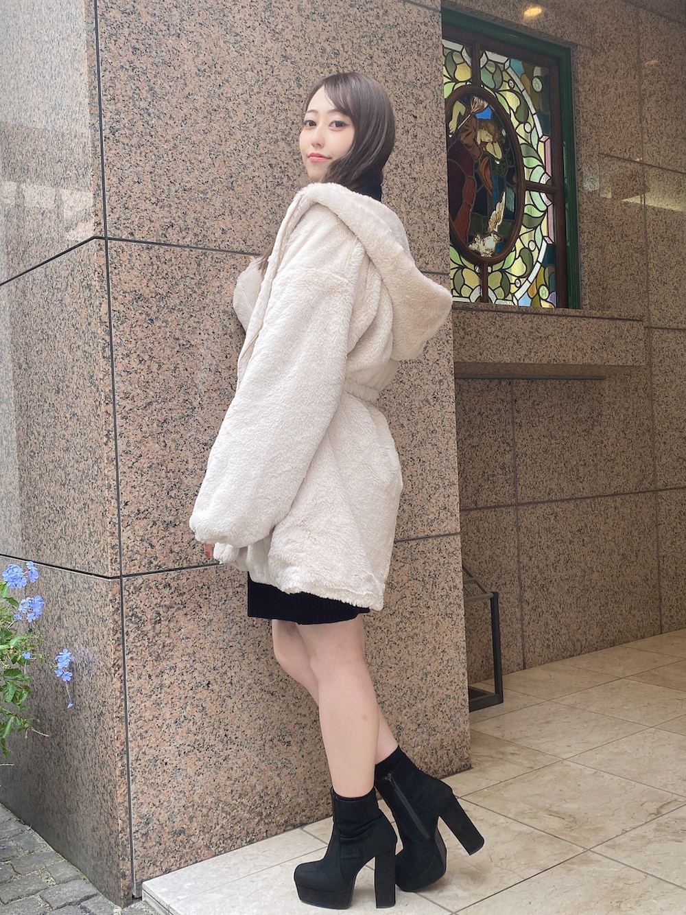 ブラック系のワンピース、ホワイト系のその他アウターを着用したレディースの冬コーディネートの3枚目の写真