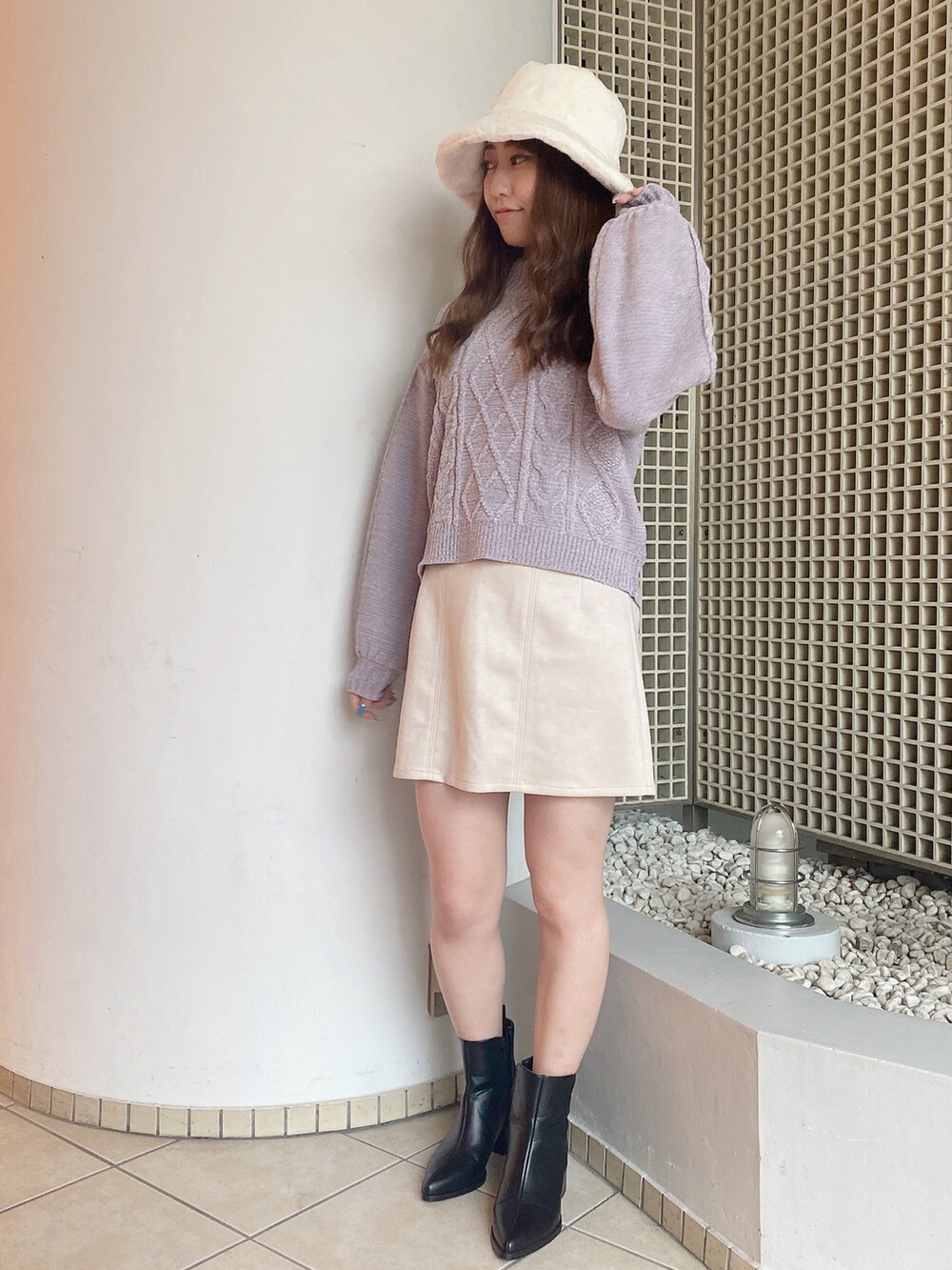 パープル系のニット/セーター、ホワイト系のスカートを着用したレディースの秋コーディネートの2枚目の写真